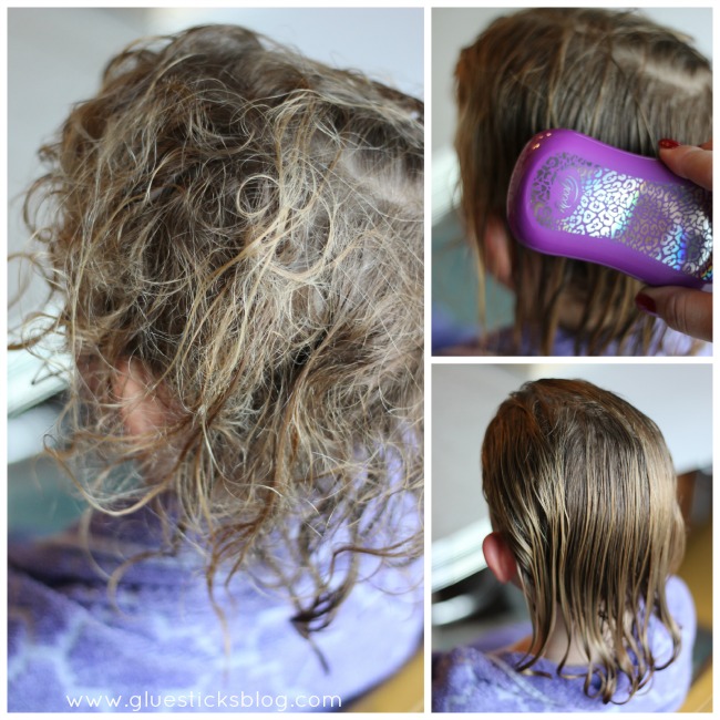 little girl having her hair brushed