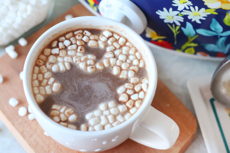 mug of hot chocolate with mini marshmallows next to slow cooker