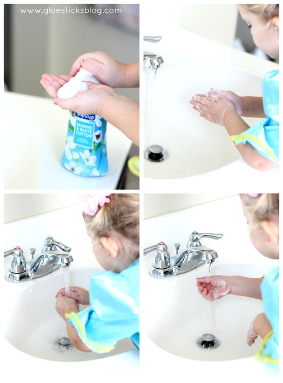 child washing hands with soap in sink