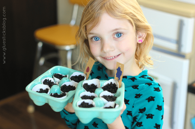 little girl holding two cartons of eggshell seed planters