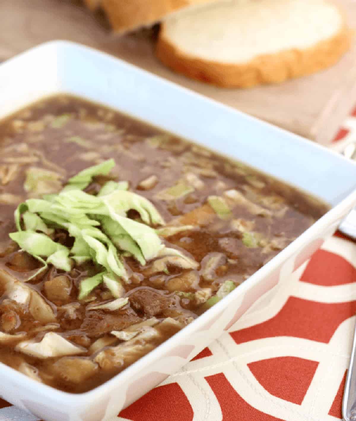 White bowl of corned beef and cabbage soup.