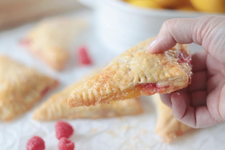 hand holding a raspberry lemon turnover