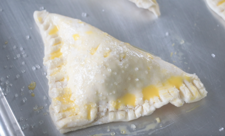 unbaked lemon raspberry turnovers on baking sheet