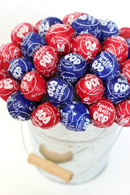 BBQ season is upon us and with Memorial Day and the 4th of July just around the corner, here is a fun patriotic lollipop topiary that the kids will love! I can guarantee that if you bring this to your next gathering it will be the hit of the party! A quick and easy lollipop topiary made in about 10 minutes.