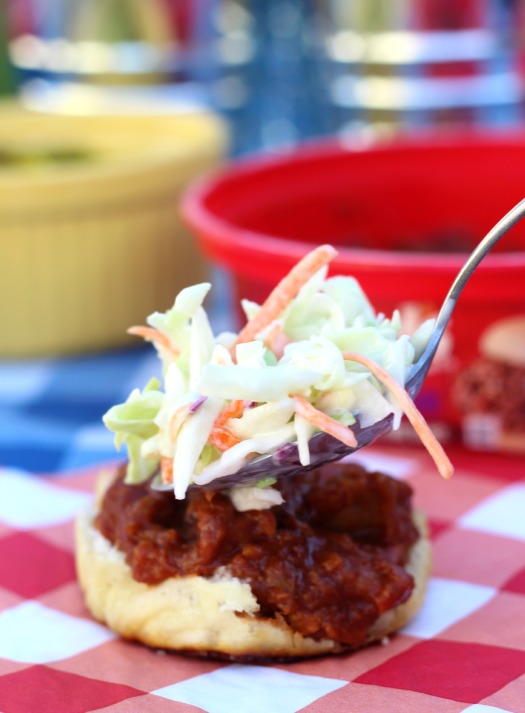 adding coleslaw to a pulled pork slider roll