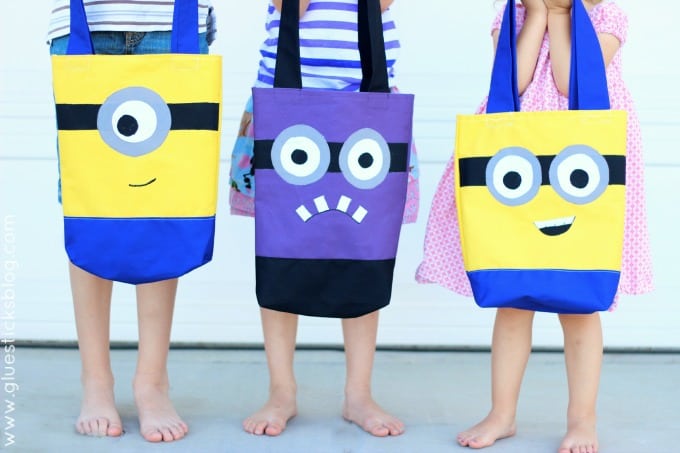 3 kids each holding a minion handbag