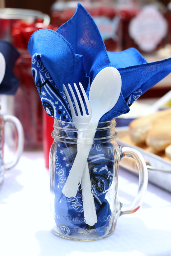 mason jar with blue bandanna and plastic cutlery
