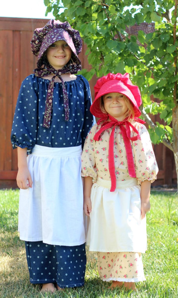 two girls wearing pioneer costumes