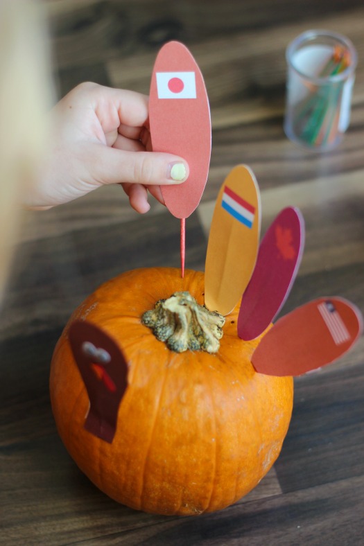 feathers with toothpicks being added to pumpkin