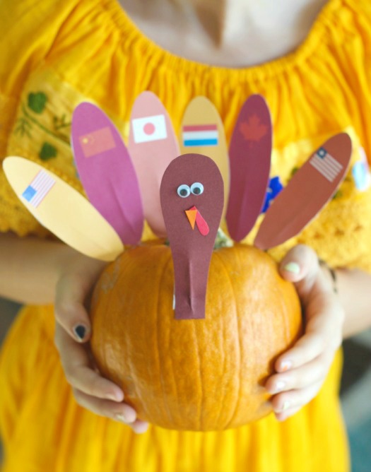 little girl with turkey pumpkin