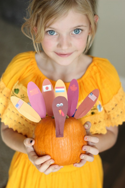 little girl holding thanksgiving around the world pumpkin