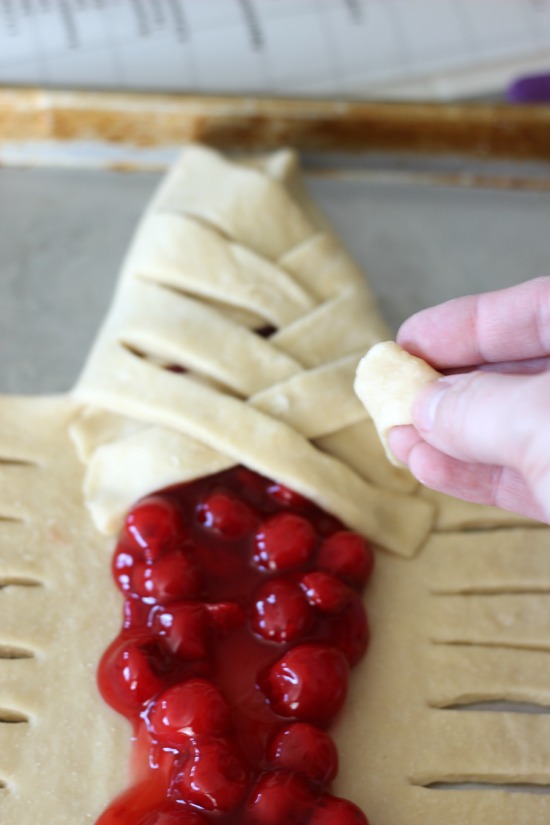 dough strips braided over cherry pie filling