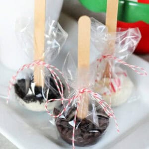 Hot chocolate sticks wrapped in plastic on a plate.