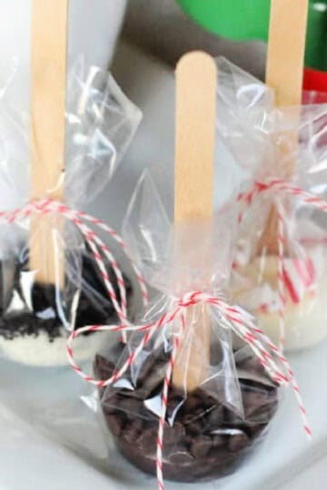 Hot chocolate sticks wrapped in plastic on a plate.