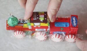 hand gluing mini candy bars to candy train