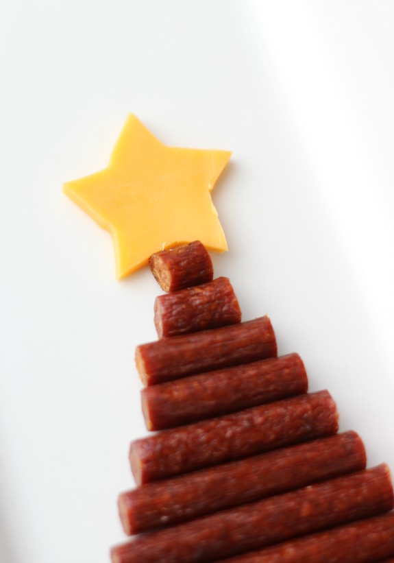 An easy snack tray to serve during the holidays made with sausage, cheese, nuts, and nuts in the shape of a tree. A yummy savory alternative to sweet treats.