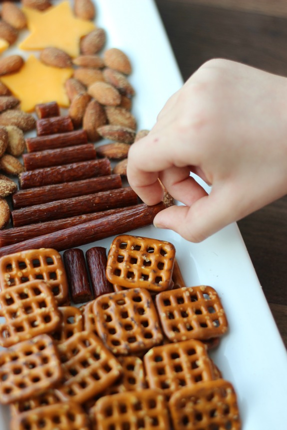 An easy snack tray to serve during the holidays made with sausage, cheese, nuts, and nuts in the shape of a tree. A yummy savory alternative to sweet treats.