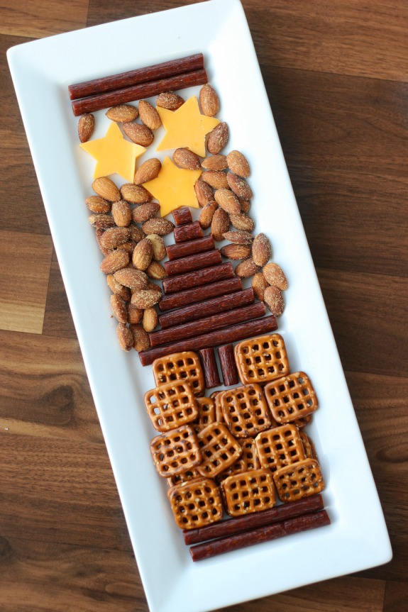 An easy snack tray to serve during the holidays made with sausage, cheese, nuts, and nuts in the shape of a tree. A yummy savory alternative to sweet treats.