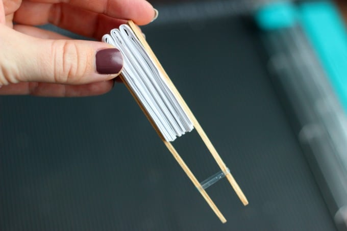 paper pocket fan glued to two popsicle sticks