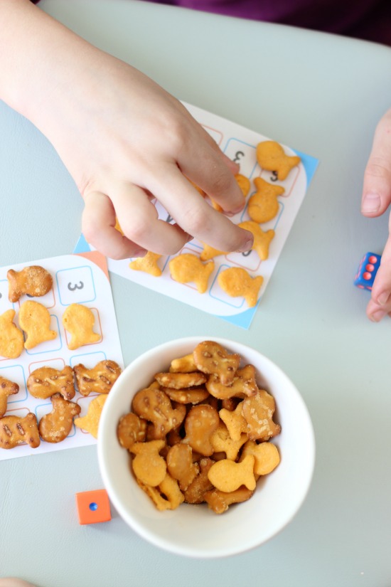 child placing goldfish crackers on game card