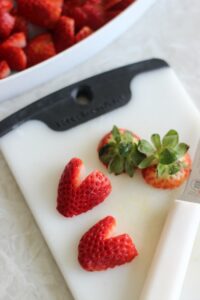 cutting board with sliced heart strawberries