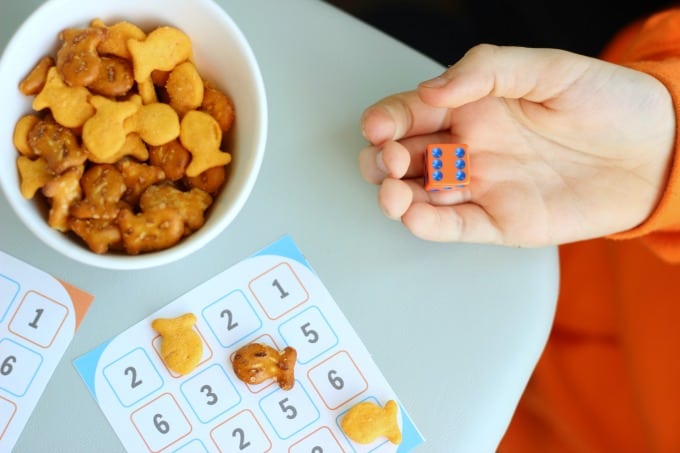 child rolling dice for game