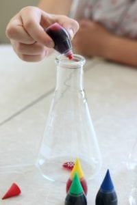 adding drops of food coloring into vase