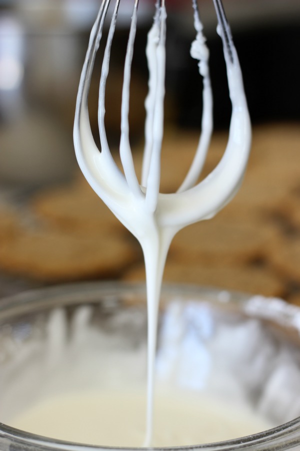 whisk with excess icing dripping off
