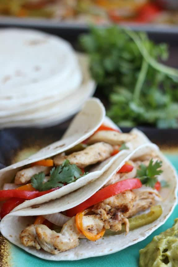 Seasoned chicken, bell peppers, onions, and sliced chicken all baked together on a sheet pan for the perfect blend of flavors. Oven fajitas are a great weeknight meal. Serve with warm flour tortillas, guacamole, and sour cream. oven fajitas in flour tortillas