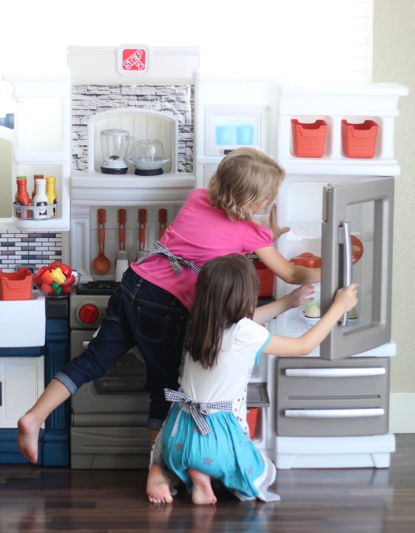 children wearing aprons playing in kitchen