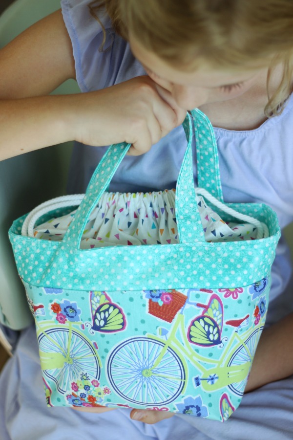 little girl holding scripture tote