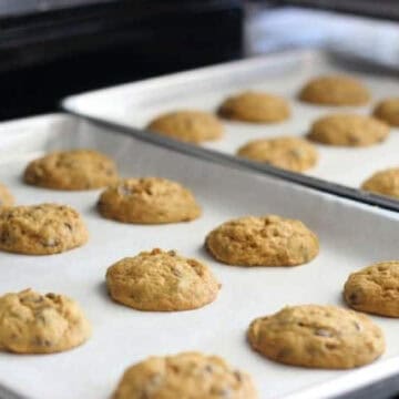 Two baking sheets of pumpkin chocolate chip cookies.