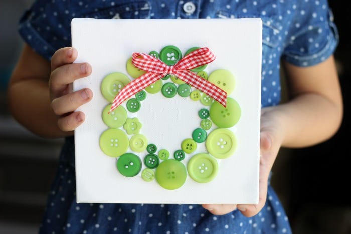 child holding button wreath wall hanging