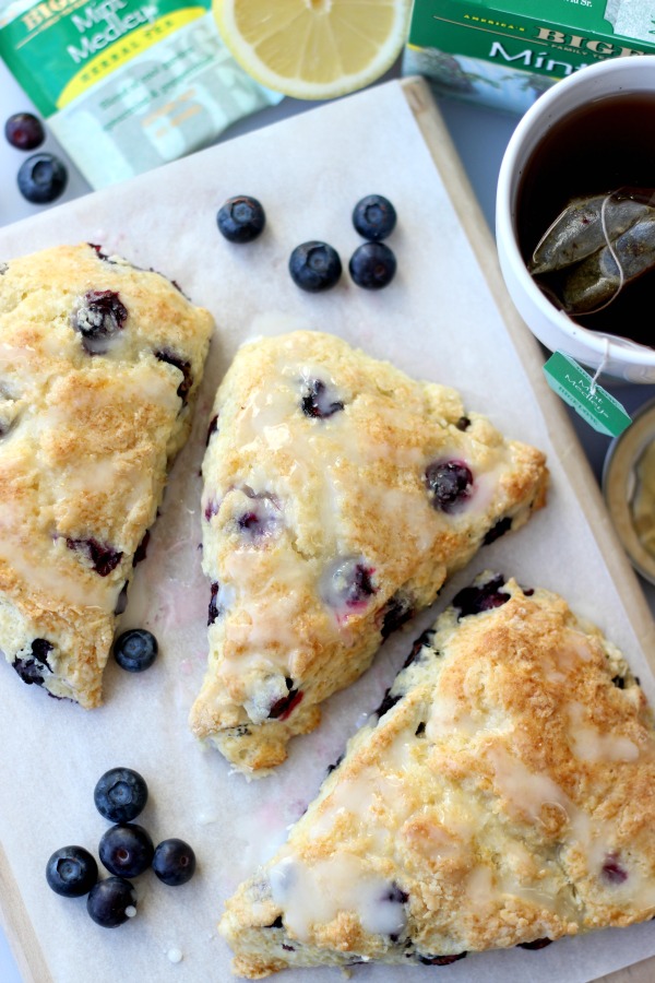 baked scones on serving board with cup of tea
