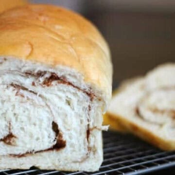 Loaf of cinnamon swirl bread on cooling rack.