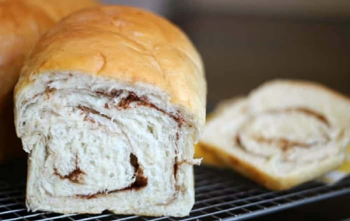 Loaf of cinnamon swirl bread on cooling rack.