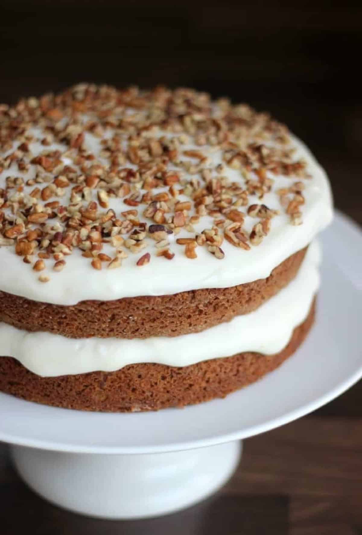 Layered carrot cake with cream cheese frosting and nuts.