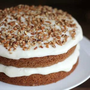 Layered carrot cake with cream cheese frosting and nuts.