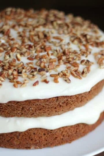 Layered carrot cake with cream cheese frosting and nuts.