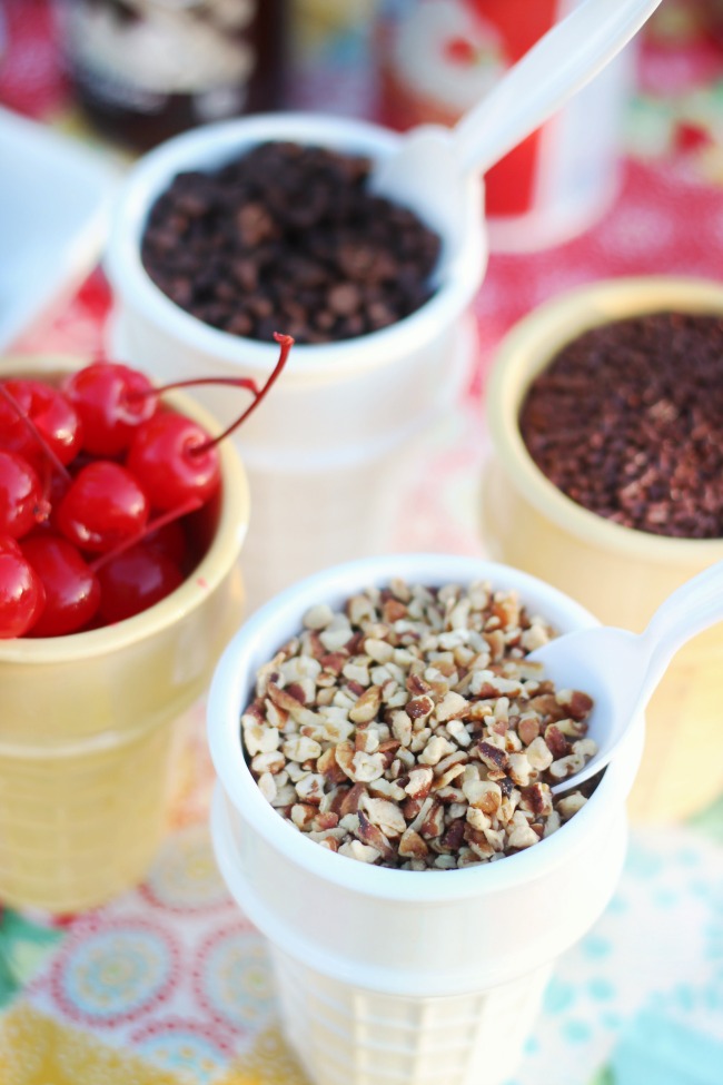 bowls of toppings for cookie sundae party. nuts, cherries, chocolate chips.