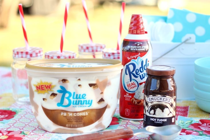 ice cream for cookie sundaes, whipped cream and hot fudge on table