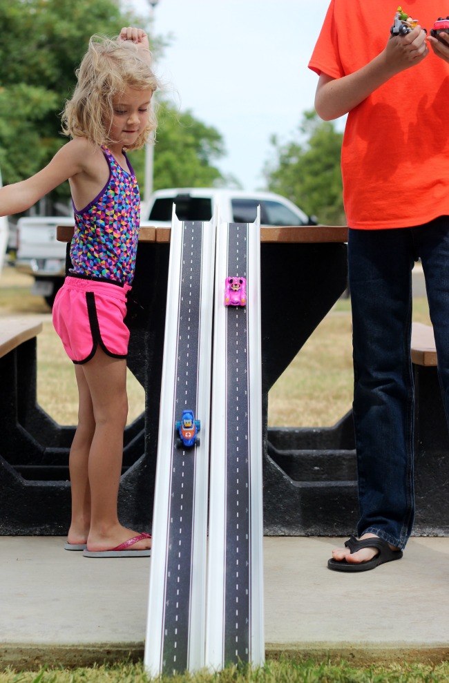 kids racing cars on rain gutter race tracks