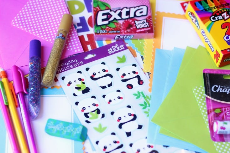 assortment of stationary, stickers, pencils, crayons and glitter glue tubes