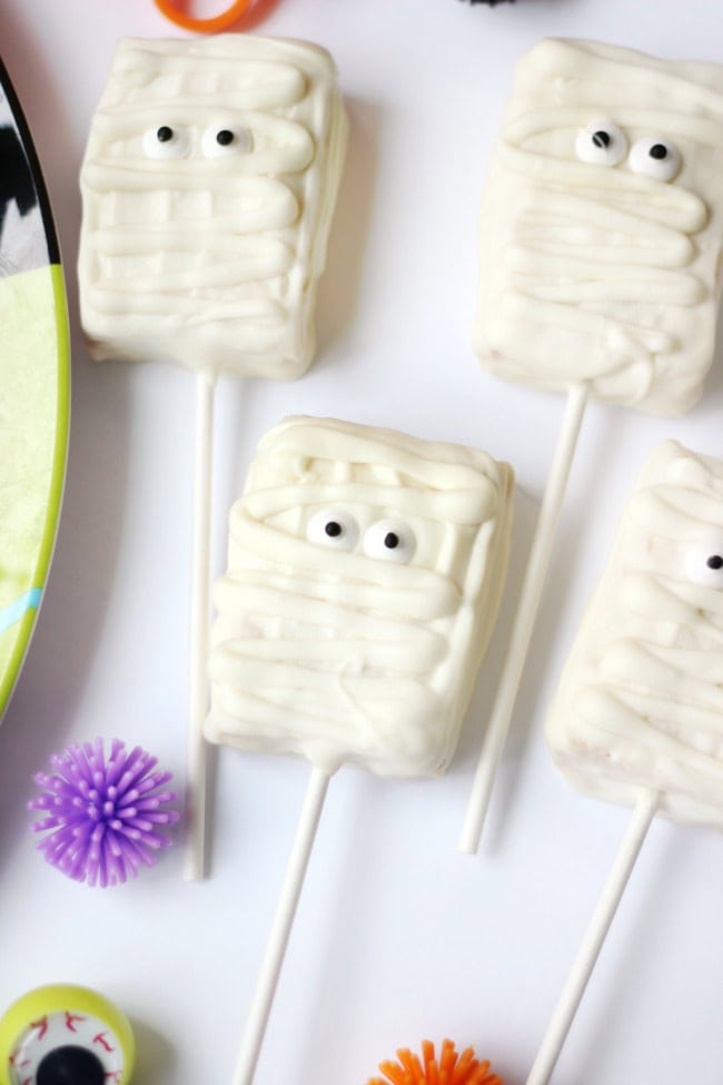 If cake pops intimidate you, don't fret! Rice Krispies pops are SO much quicker and easier and you can customize them a million ways. These mummy pops take about 10 minutes to make start to finish and are perfect for packaging up in Halloween treat bags!