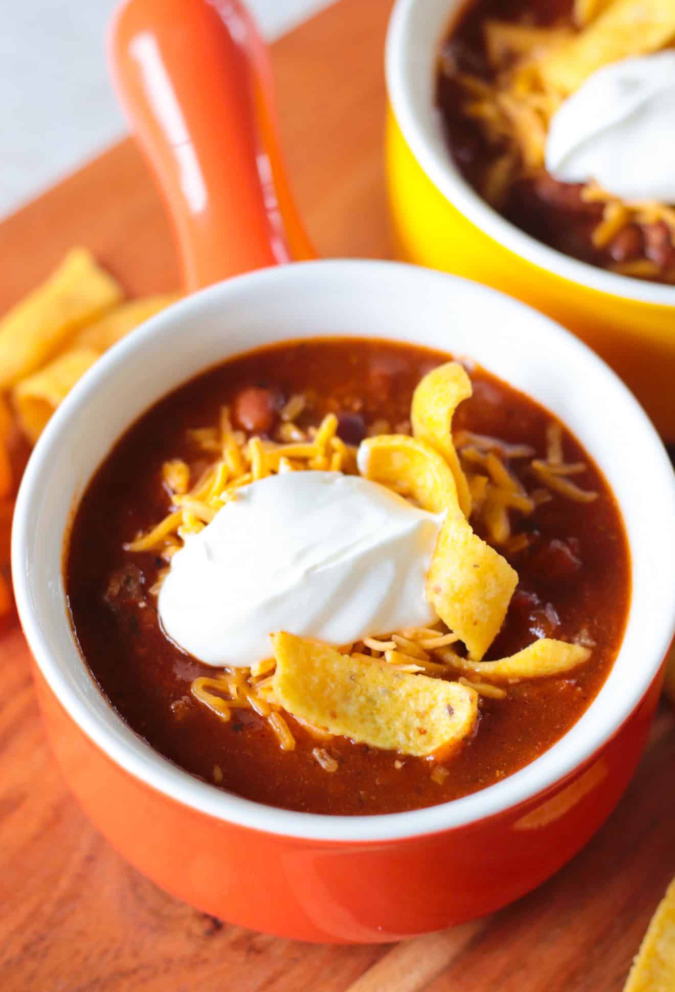 Orange bowl of turkey chili and fixings.