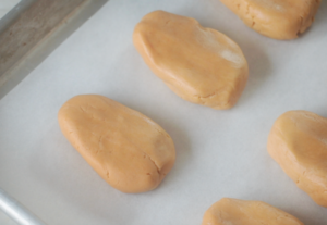 peanut butter filling shaped into egg shapes on baking sheet