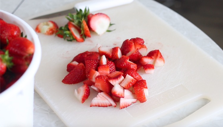chopped strawberries on cutting board