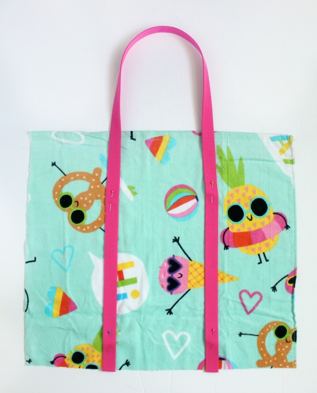 A DIY beach bag made out of a beach towel! Grab a fun and funky towel and let's get started! The perfect bag for towels, sunscreen, and treats to share with friends at the pool this summer!