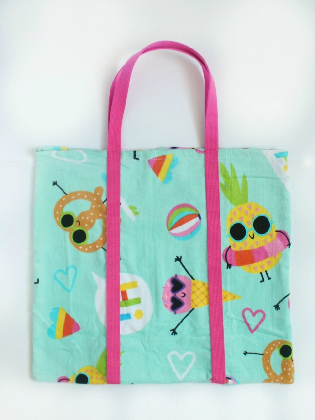 A DIY beach bag made out of a beach towel! Grab a fun and funky towel and let's get started! The perfect bag for towels, sunscreen, and treats to share with friends at the pool this summer!