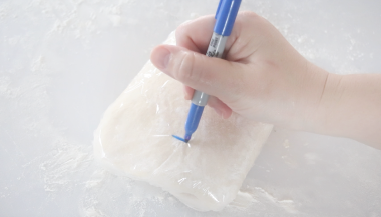 dough wrapped in plastic wrap with pen writing a number 1 on it